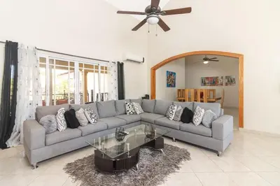 a living room with a couch and a table at Luxe Comfort 8 Bedroom Villa with Private Pool & Entertainment in Sosúa