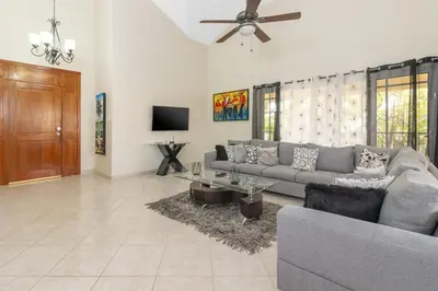 a living room with a couch and a ceiling fan at Luxe Comfort 8 Bedroom Villa with Private Pool & Entertainment in Sosúa