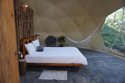 a bedroom with a bed in a tent at NOMAD Domes Sky Watching at Jarabacoa in Jarabacoa