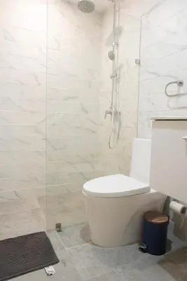 a bathroom with a white toilet and a shower at Torre Opus 31 - Apto.605 in Santo Domingo