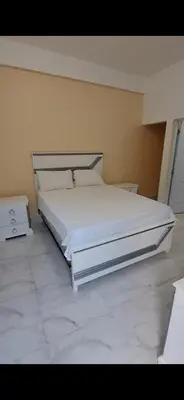 a bedroom with a large white bed and a tiled floor at Hotel Villa Marchena in Azua de Compostela