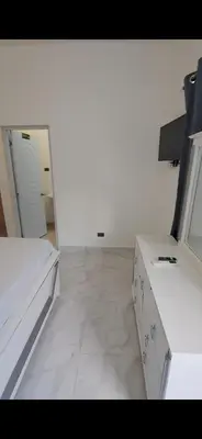 a white room with a bed and a desk and a mirror at Hotel Villa Marchena in Azua de Compostela