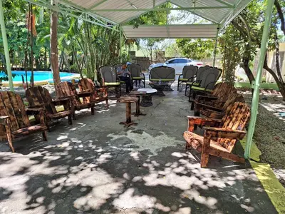 a group of wooden chairs and tables under a tent at Hotel Villa Marchena in Azua de Compostela