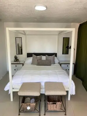 a bedroom with a large white bed with two chairs at Blessed house 