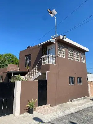 a brown building with a flag on top of it at Blessed house 