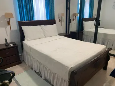 a bedroom with two beds with blue curtains at Residencia Katya in La Romana