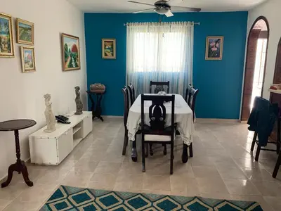 a dining room with a table and blue walls at Residencia Katya in La Romana
