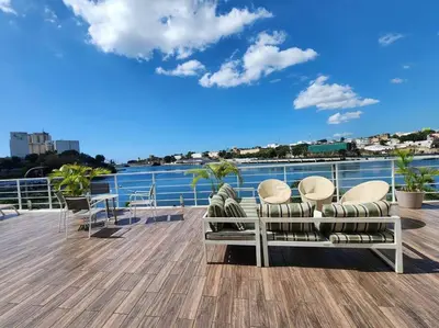 a deck with chairs and a view of the water at Apartamento Riviera Colonial, Santo Domingo in Calero
