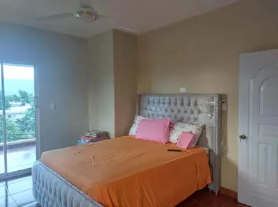 a bedroom with a bed with pink pillows on it at New apartment close to everything in Santiago de los Caballeros