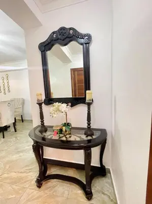 a small table with a mirror on a wall at Super Cozy n´Confortable apart. in Ensanche Los Minas