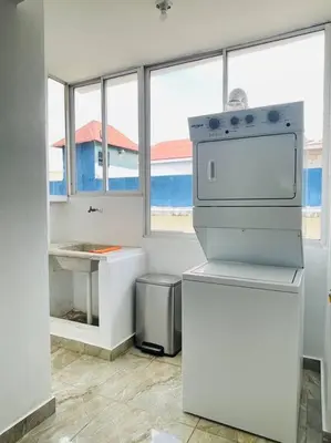 a kitchen with a stove and a sink and windows at Super Cozy n´Confortable apart. in Ensanche Los Minas