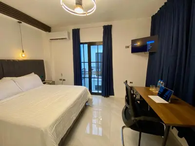 a bedroom with a bed and a desk with a laptop at RIG Colonial Experience in Santo Domingo