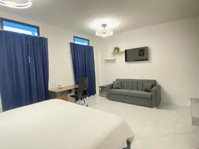 a bedroom with a bed and a couch and a desk at RIG Colonial Experience in Santo Domingo