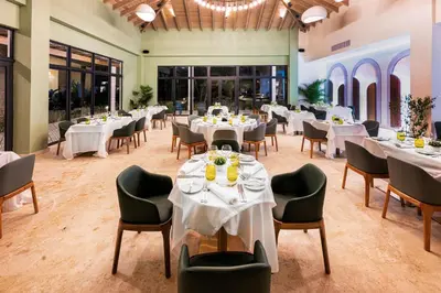 a dining room with white tables and chairs at Viva Miches by Wyndham, a Trademark All Inclusive Resort in Miches