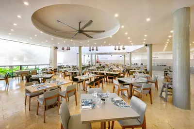 a restaurant with tables and chairs and a clock on the ceiling at Viva Miches by Wyndham, a Trademark All Inclusive Resort in Miches