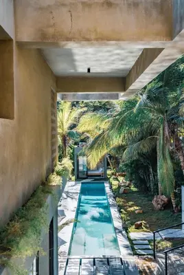 an indoor swimming pool in a house with palm trees at Casa Ataraxia Modern Luxe Villa in Las Terrenas