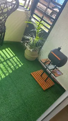 a room with green carpet and a grill and plants at Acogedor apartamento amueblado in Los Paredones
