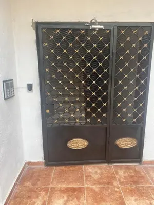 a black door with gold spikes on it at Acogedor apartamento amueblado in Los Paredones