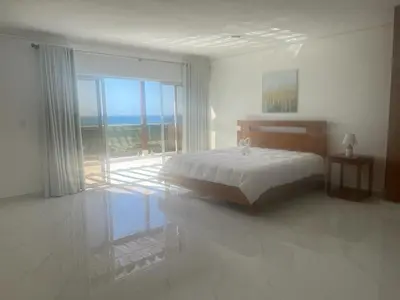 a white bedroom with a bed and a large window at Luxury Beach Front Villa with Private pool and stunning Ocean View! in Punta Rucia