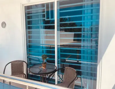 a table and chairs on a balcony with a window at A Caribbean-style rebirth, 2 minutes from the beach in La Romana