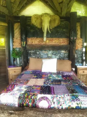 a bedroom with a bed with an elephant on the wall at Casa El Paraiso, Eco Lodge in Santa Bárbara de Samaná