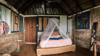 a bedroom with a bed with a mosquito net at Casa El Paraiso, Eco Lodge in Santa Bárbara de Samaná