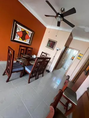 a living room with a ceiling fan and a table and chairs at Bello Apartamento en Santiago con todas las comodidades in Santiago de los Caballeros