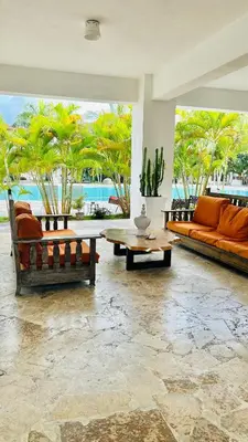 a living room with orange couches and a table at Bayahibe Paraíso in Bayahibe
