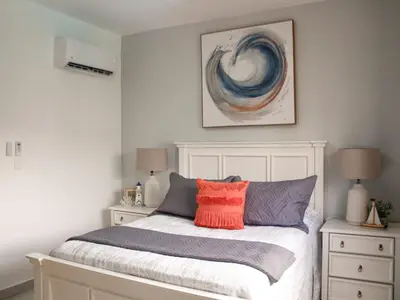 a bedroom with a white bed with a red pillow at Apartamento de Ensueño en Las Terrenas Penthouse in Las Terrenas