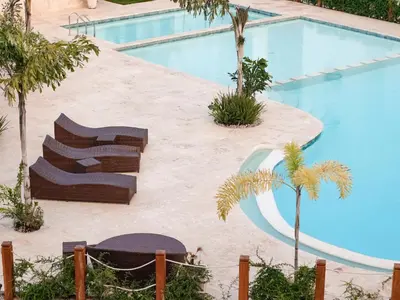 a swimming pool with two lounge chairs next to it at Apartamento de Ensueño en Las Terrenas Penthouse in Las Terrenas