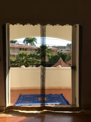 an open window with a view of a palm tree at Caraibidamari in Bayahibe