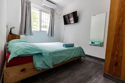 a bedroom with a bed with green sheets and a window at Mango House. Mono 2 bedrooms in Cabarete