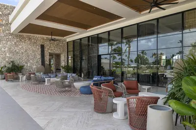 a lobby with chairs and tables and windows at Zemi Miches Punta Cana All-Inclusive Resort, Curio by Hilton in Miches