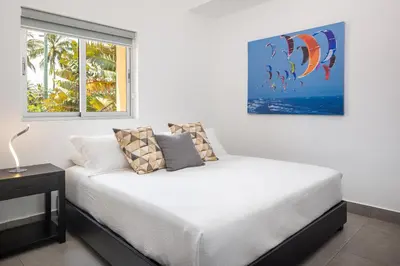 a bedroom with a white bed and a window at Kite Beach Penthouse in Cabarete