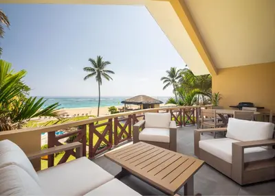 a balcony with chairs and tables and the beach at Kite Beach Penthouse in Cabarete