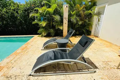 a pair of chairs sitting next to a swimming pool at Casa Linda Villa 920 - Sosua in Sosúa