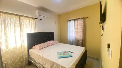 a small bedroom with a bed and a television at Estefany Aparment New in San Felipe de Puerto Plata