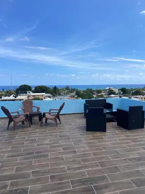 a patio with chairs and a table on a roof at Estefany Aparment New in San Felipe de Puerto Plata