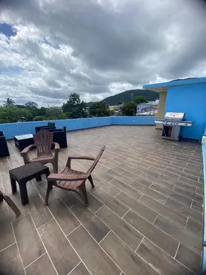 a patio with two chairs and a bench on a roof at Estefany Aparment New in San Felipe de Puerto Plata
