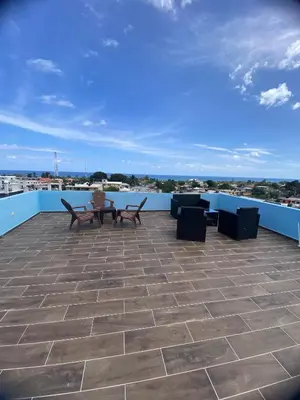 a patio with benches and tables on a roof at Estefany Aparment New in San Felipe de Puerto Plata