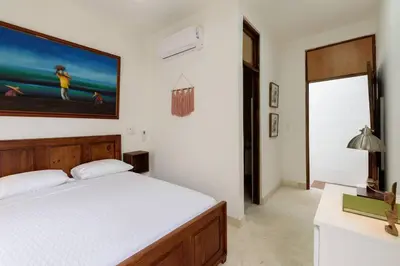 a bedroom with a bed and a painting on the wall at Guacanagarix 2-Bedroom Apt Casaareito in Santo Domingo