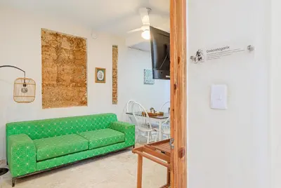 a living room with a green couch and a table at Guacanagarix 2-Bedroom Apt Casaareito in Santo Domingo