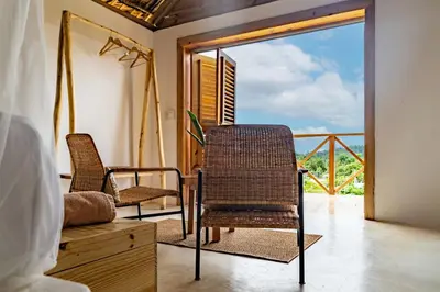 a room with two chairs and a balcony at Margarita Ecovillage in Miches