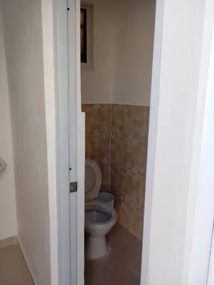 a bathroom with a white toilet in a room at Lujosa y espaciosa Villa María. in Santiago de los Caballeros