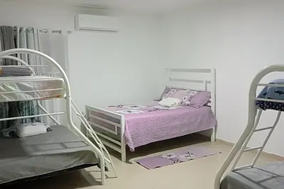 a bedroom with a bed and two bunk beds at Lujosa y espaciosa Villa María. in Santiago de los Caballeros