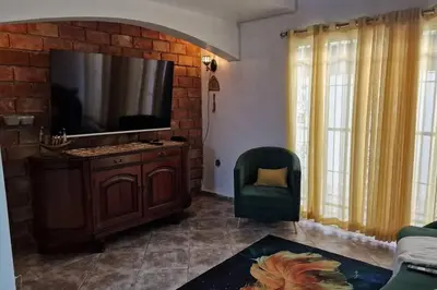 a living room with a tv on a brick wall at Lujosa y espaciosa Villa María. in Santiago de los Caballeros