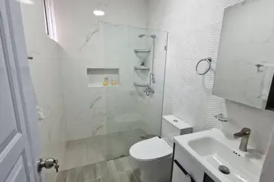 a bathroom with a shower and a toilet and a sink at Lujosa y espaciosa Villa María. in Santiago de los Caballeros