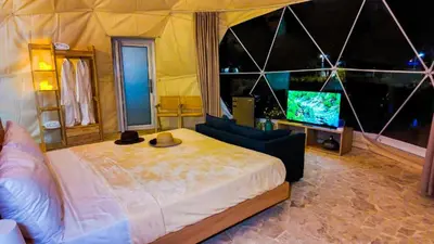 a bedroom with a large bed and a television at Bubble Glamping Sosua! in Sosúa