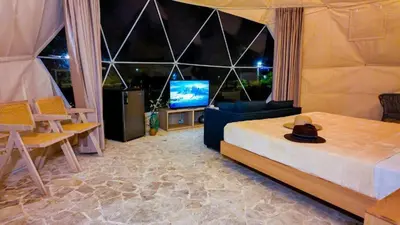 a bedroom with a bed and a television with a hat at Bubble Glamping Sosua! in Sosúa