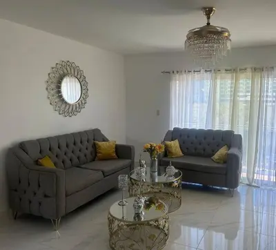 a living room with a couch and two tables at Acogedor Sweet Apartament in Santiago de los Caballeros